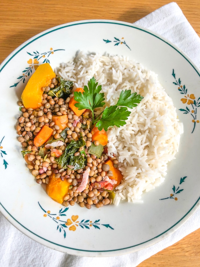 a plate with half lentils with vegetables, half rice